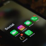 Close de um smartphone exibindo ícones de aplicativos de redes sociais na tela.