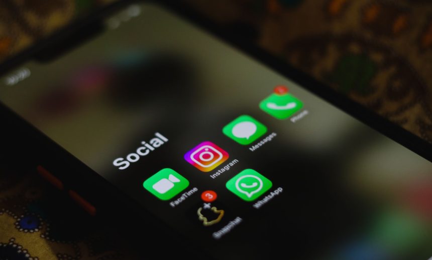 Close de um smartphone exibindo ícones de aplicativos de redes sociais na tela.